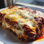 Close-up of a serving of baked chicken parmesan recipe, covered in melted mozzarella and tomato sauce.