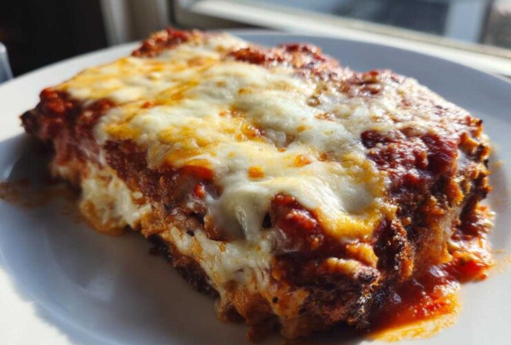 Close-up of a serving of baked chicken parmesan recipe, covered in melted mozzarella and tomato sauce.