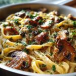 Close-up of rich, creamy mushroom pasta featuring fettuccine noodles, sautéed mushrooms, and fresh parsley.