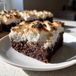A close-up of a fudgy hot chocolate brownies square topped with fluffy, toasted marshmallow.