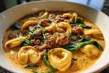 Close-up of a hearty bowl of Italian Sausage Tortellini Soup with spinach and creamy broth.