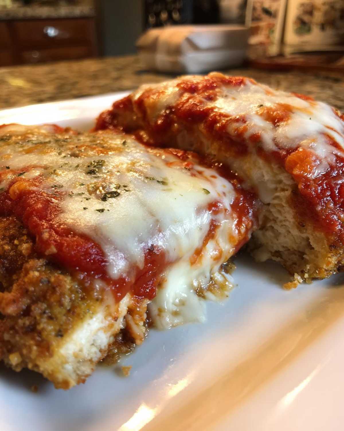Close-up of two servings of keto chicken parmesan topped with melted mozzarella and marinara sauce.