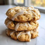 A stack of three soft maple brown sugar cookies drizzled generously with a white vanilla glaze.