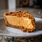 A close-up slice of creamy no bake pumpkin pie with a thick graham cracker crust and crumb topping.