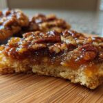 Cross-section view of a delicious pecan pie cookie showing the thick, buttery crust and gooey pecan topping.