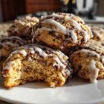 A stack of soft coffee cake cookies drizzled with white icing, one cookie has a bite taken out.