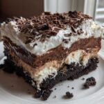 A rich, layered slice of Baileys Chocolate Cheesecake Trifle topped with whipped cream and chocolate shavings.