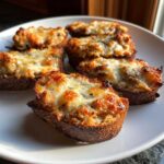 Close-up of five baked bread slices topped with cheesy, savory filling from the hanky panky recipe.