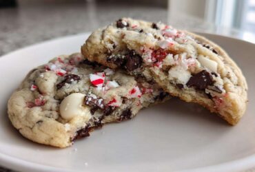 Close-up of chewy peppermint chocolate chip cookies broken in half, showing melted chips and crushed candy canes.