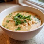 A close-up of a creamy bowl of keto white chicken chili topped generously with fresh cilantro.