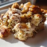 Close-up of a serving of moist crock pot chicken and stuffing topped with savory gravy.