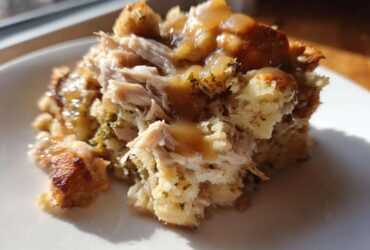 Close-up of a serving of moist crock pot chicken and stuffing topped with savory gravy.
