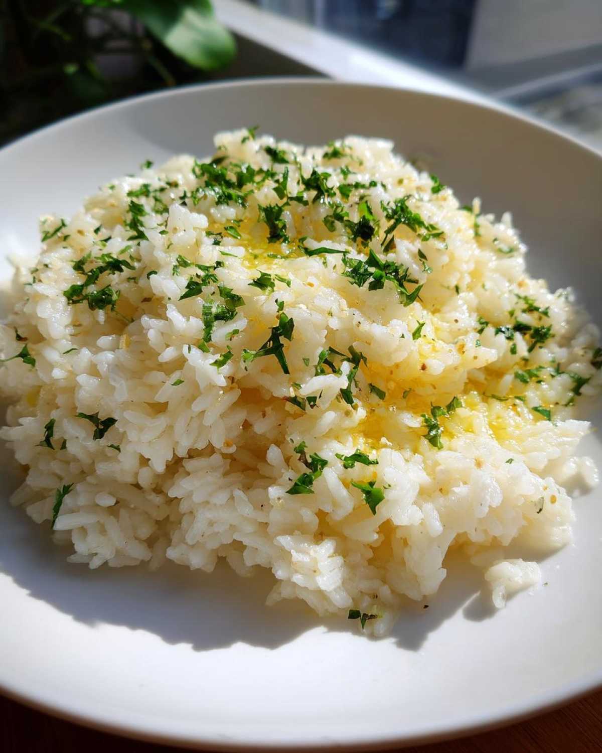 A close-up of fluffy white rice seasoned with melted butter and fresh chopped parsley, representing delicious butter rice.