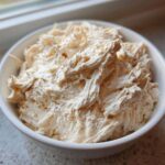 Close-up of fluffy, shredded chicken mixed into a creamy base, representing homemade cream of chicken soup.