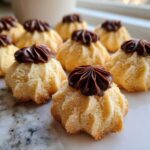 Close-up of freshly baked Italian butter cookies topped with piped chocolate ganache.