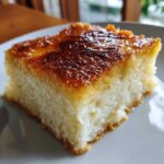 Close-up of a square slice of moist cassava cake with a beautifully caramelized, golden-brown top layer.
