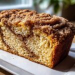 Close-up of a moist slice of snickerdoodle zucchini bread featuring a thick cinnamon-sugar crumb topping.