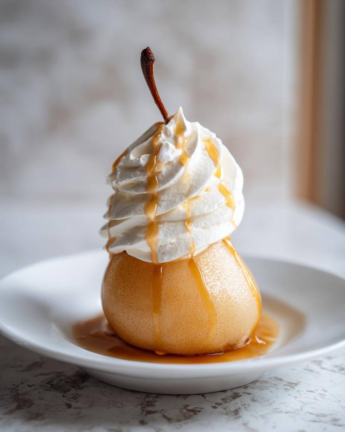 A single, beautifully poached pears topped with a swirl of whipped cream and drizzled with caramel sauce.