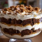 Close-up of a stunning gingerbread trifle layered with cake, cream, and caramel sauce.
