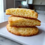 Close-up of three halves of a soft, thick sugar cookie stacked, showing the fluffy interior texture.