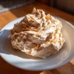 A generous mound of freshly whipped cinnamon butter sprinkled with extra spice on a white plate.