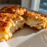 Close-up of Air Fryer Salmon Patties, one broken open showing flaky interior and crispy golden crust.