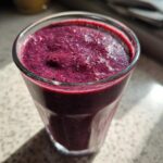 Close-up of a vibrant, thick Blueberry Lemon Chia Smoothie topped with visible chia seeds.