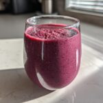 Close-up of a vibrant, deep purple Blueberry Lemon Chia Smoothie topped with visible chia seeds.