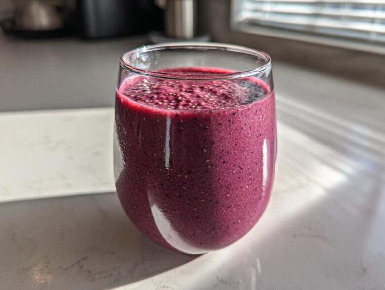 Close-up of a vibrant, deep purple Blueberry Lemon Chia Smoothie topped with visible chia seeds.