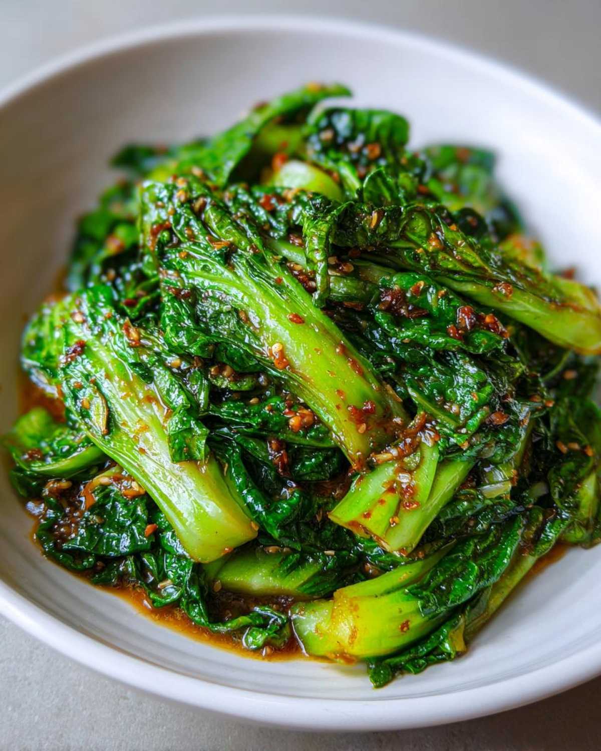Close-up of vibrant green bok choy in a Cabbage Stir Fry with Garlic Ginger Sauce, coated in a savory glaze.