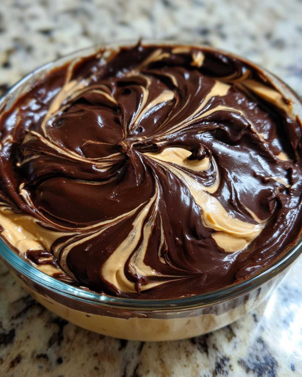 Close-up of Chocolate Peanut Butter Cheesecake Dip with rich chocolate and peanut butter swirled together in a glass bowl.