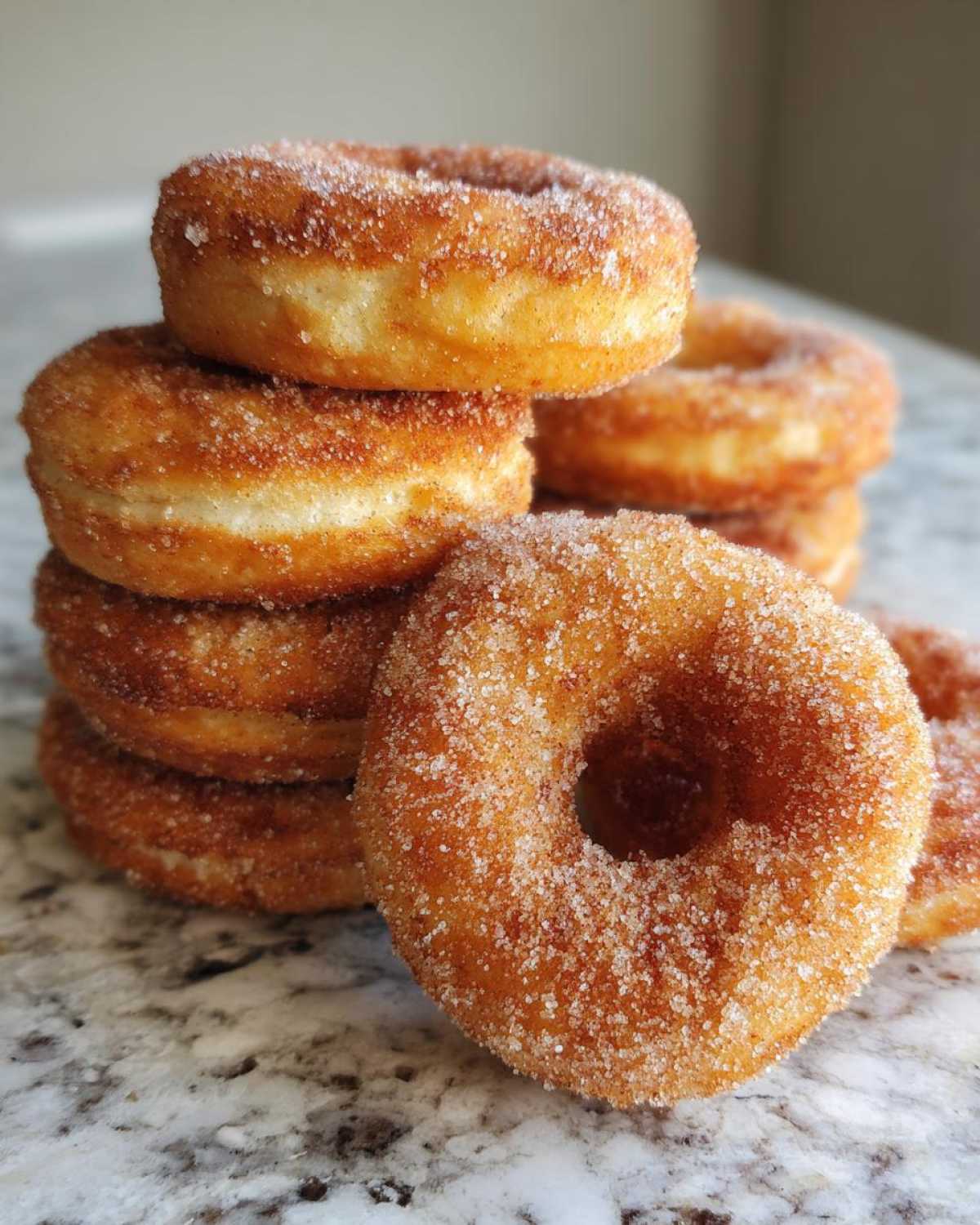 Close-up of a stack of golden brown Cinnamon Sugar Air Fryer Donuts heavily coated in sparkling sugar.