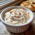 Creamy Copycat Taco Bell Chicken Quesadilla Sauce topped with red pepper flakes in a white bowl.