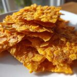 Close-up of golden, crispy cornflake crust pieces used for Crispy Baked Chicken Tenders.