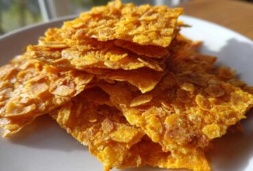 Close-up of golden, crispy cornflake crust pieces used for Crispy Baked Chicken Tenders.