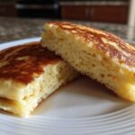 Close-up of fluffy Gluten-Free Buttermilk Pancakes cut in half showing the airy interior texture.
