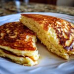 Close-up showing the fluffy, golden interior texture of Gluten-Free Buttermilk Pancakes stacked on a white plate.