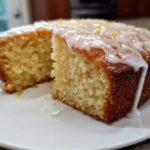 Close-up of a moist Gluten-Free Lemon Coconut Cake with white glaze dripping down the side.
