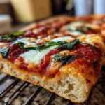 Close-up of a thick slice of Gluten-Free Margherita Pizza showing bubbly crust, tomato sauce, mozzarella, and basil.