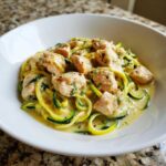 Close-up of Keto Chicken Alfredo served over zucchini noodles (zoodles) in a white bowl.
