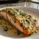 Close-up of a perfectly cooked Keto Garlic Butter Salmon fillet glistening with melted butter and topped with fresh parsley and garlic.
