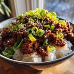 A close-up of Korean Ground Beef Bulgogi Bowls featuring seasoned ground beef over white rice, topped with sesame seeds and sliced green onions.