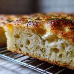 Close-up cross-section showing the airy, open crumb structure of No-Knead Skillet Focaccia with Rosemary.