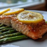 Close-up of a perfectly cooked piece of One-Pan Lemon Garlic Salmon with Asparagus topped with lemon slices.
