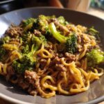 Close-up of a bowl of One-Pot Beef and Broccoli Ramen Noodles with savory sauce coating the noodles, beef, and bright green broccoli florets.