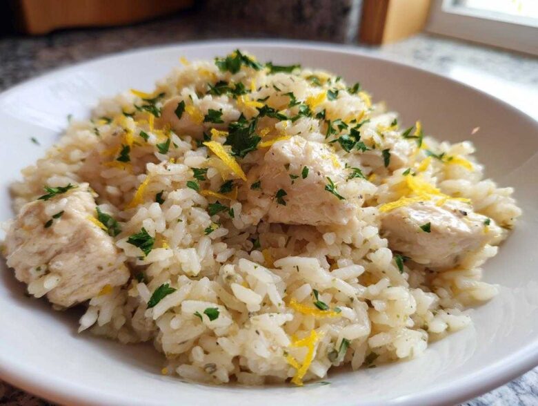 A close-up of One-Pot Chicken and Rice with Lemon and Herbs, topped with fresh parsley and lemon zest.