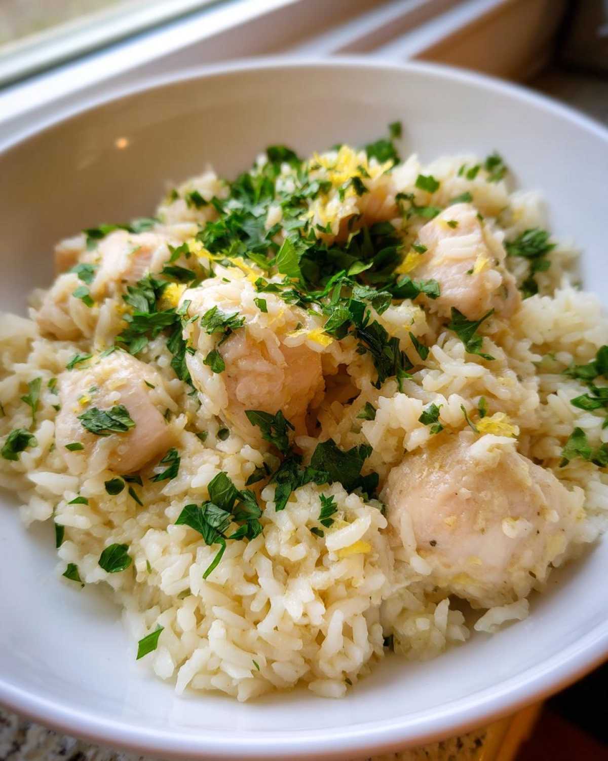 Close-up of One-Pot Chicken and Rice with Lemon and Herbs topped with fresh parsley and zest.