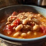 Close-up of a steaming bowl of Spicy Turkey White Bean Chili with ground turkey, white beans, and diced tomatoes.
