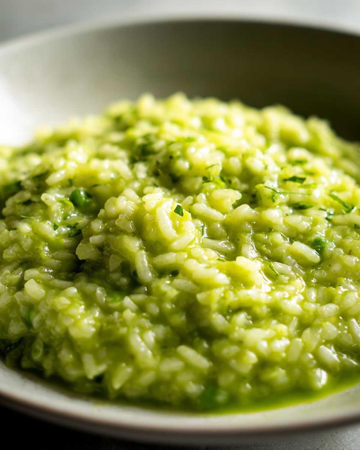 Close-up of creamy, vibrant green Spring Pea and Mint Risotto in a light bowl.