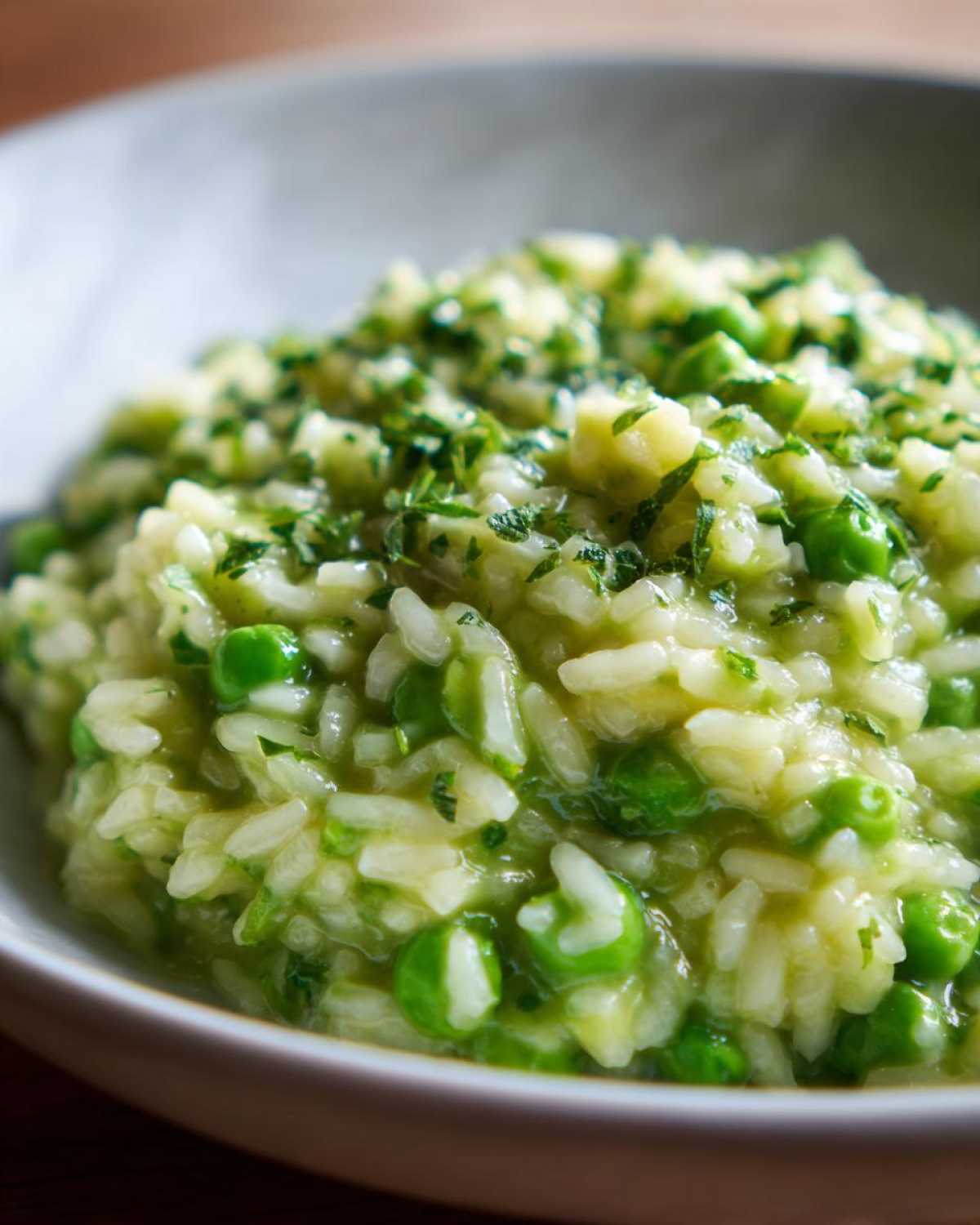 Close-up of creamy Spring Pea and Mint Risotto, garnished with fresh chopped herbs.